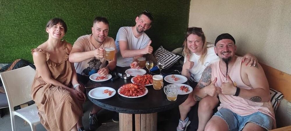 Happy customers enjoying fresh crayfish and drinks at Los Crayfish Hermanos rooftop bar, Tbilisi